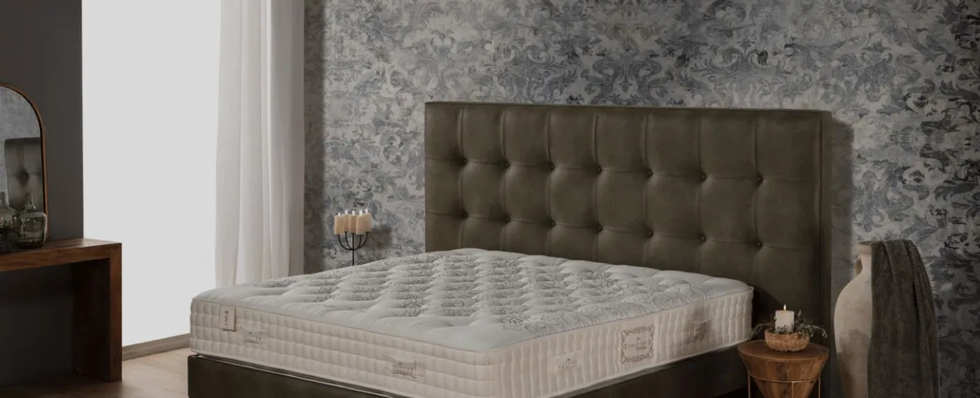 Colchón de la colección Heritage sobre una cama con cabecero capitoné