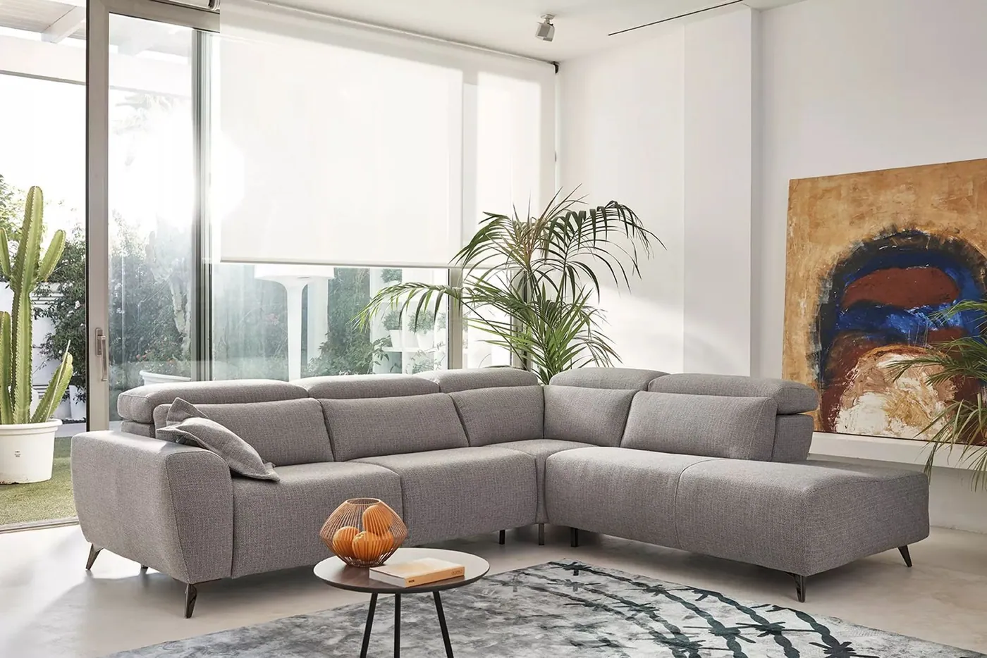 Sofá rinconera gris en un salón luminoso
